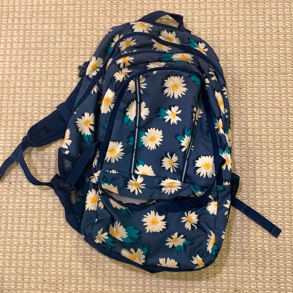 A navy blue floral backpack (daisies).